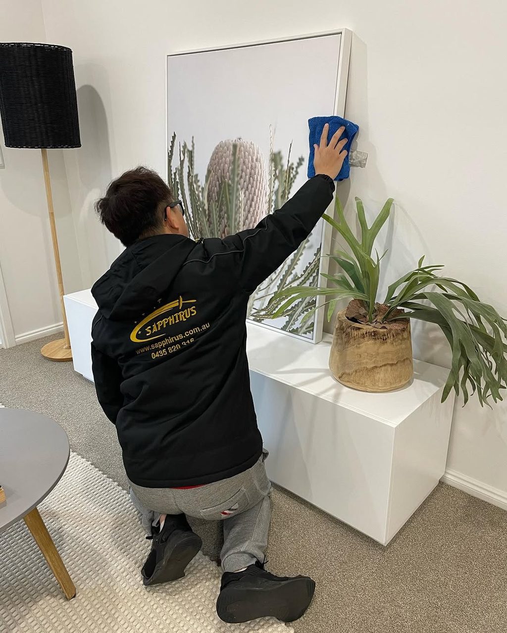 Uniformed Sapphirus cleaner preparing an indoor facility surface